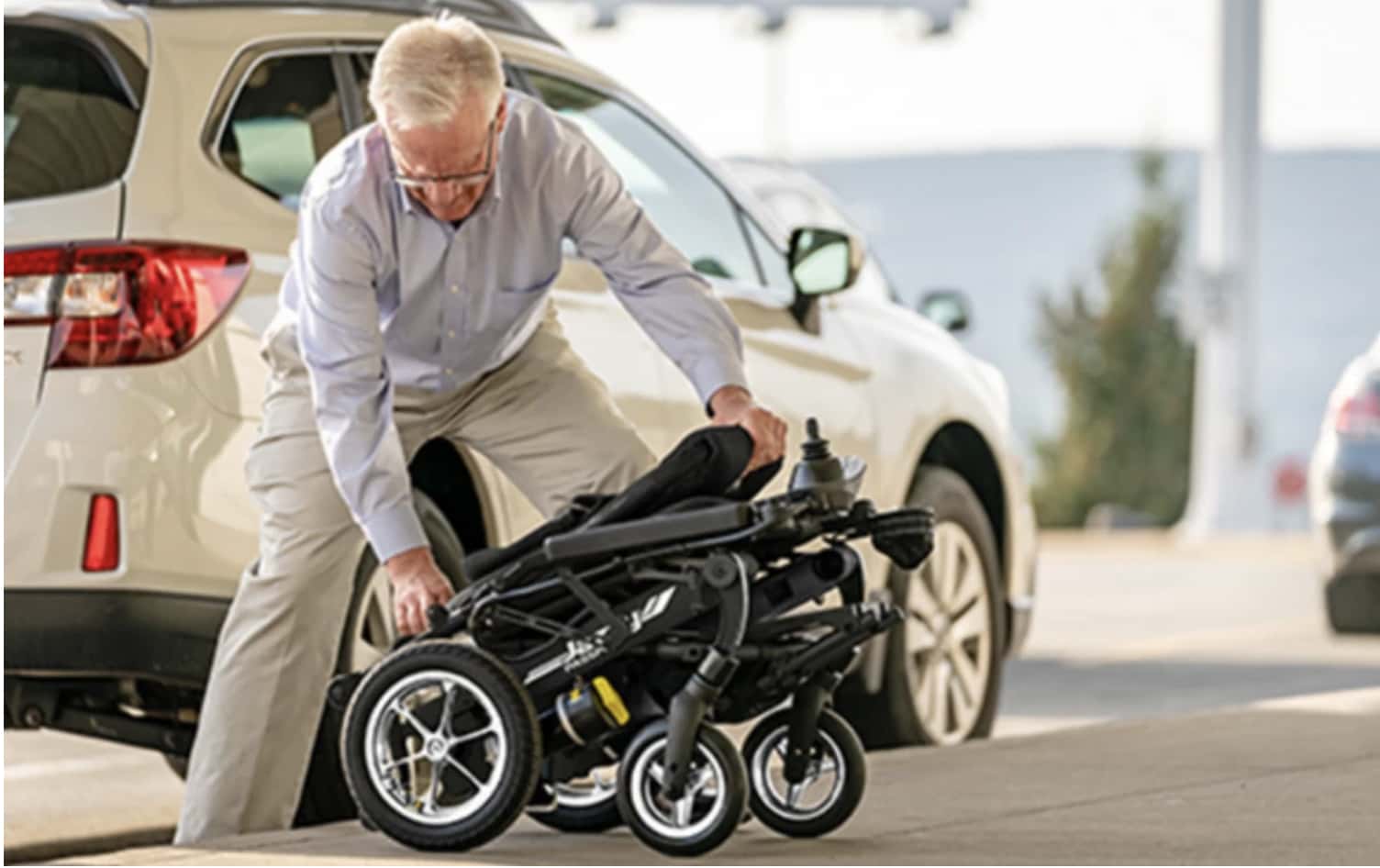 Man folding Electric Wheelchair